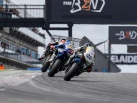 The back of three bikes racing on the track