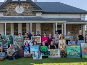 People holding artworks infront of historic building