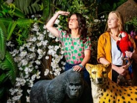 Leigh Sales and Annabel Crabb pose with a gorilla and a cheetah in jungle setting