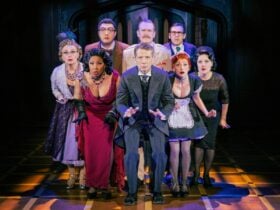 Production image of theatre performance of Cluedo with cast acting on stage in costume