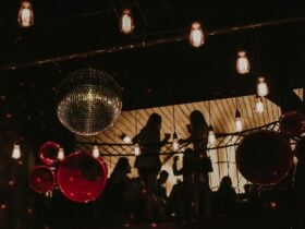 Two Girls dance up in the loft, as a disco ball hangs in the foreground.