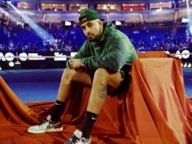 man in arena sitting in on chair which is draped in cloth