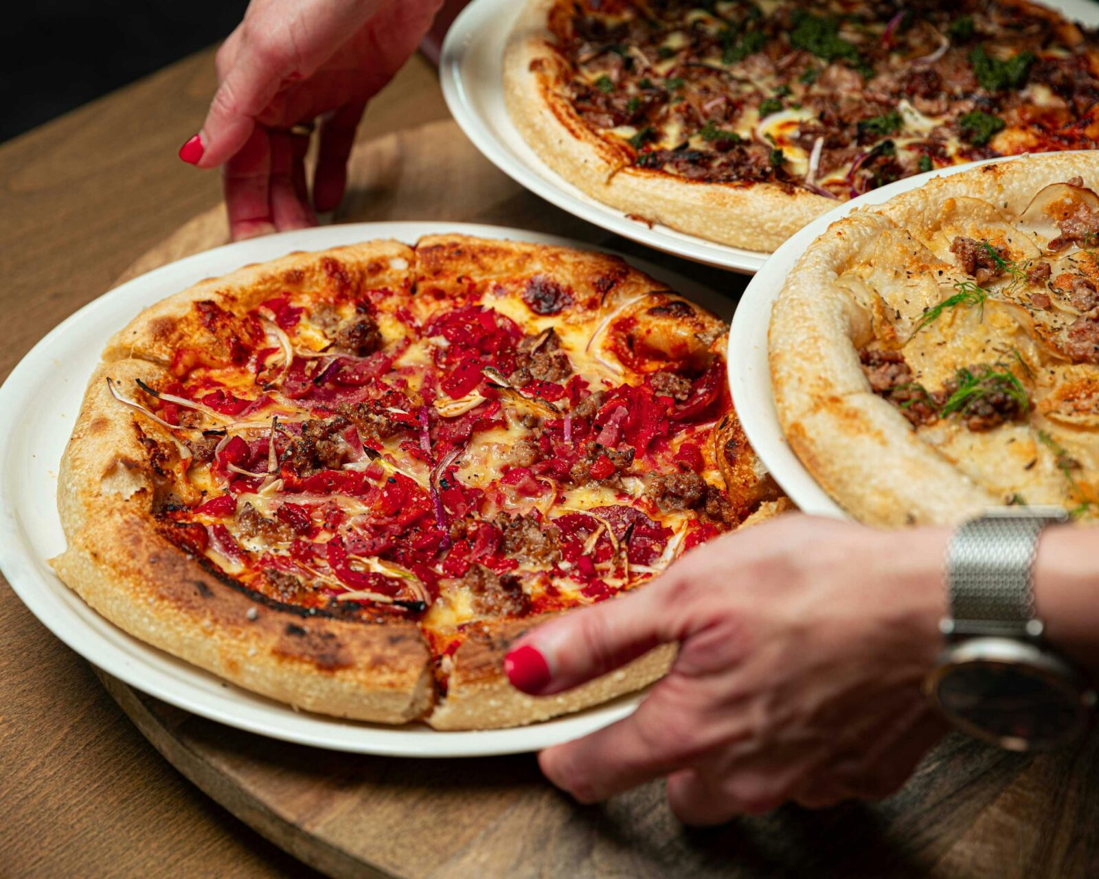hands placing a pizza on table
