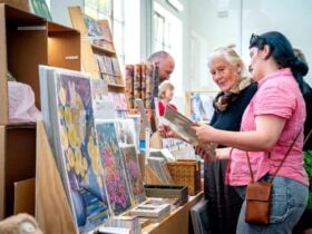 Browsing colorful art prints and handmade goods at FABRIK Arts + Heritage Handmade Christmas Market