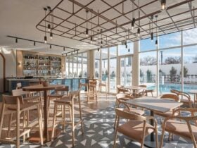Bar with tables and chairs & pool in the background