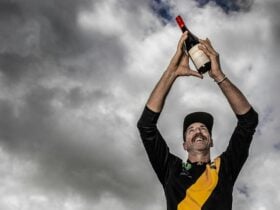 Adam Fiegert marking a bottle of Duke Grenache high in the sky.