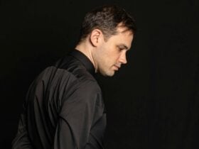 Kristian Winther posed reflectively in front of a black background.