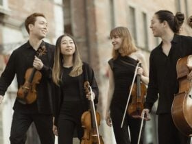 Leonkoro Quartet walking down a street with their instruments.