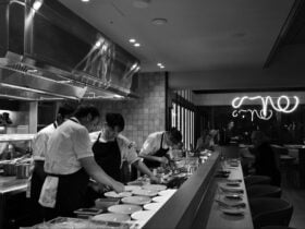 Chefs in a kitchen preparing lots of plates