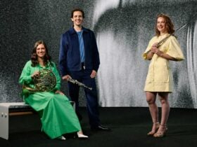 Three Adelaide Symphony Orchestra players smiling against a black and white background.