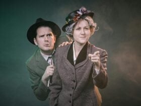 A detective and an eccentric elderly sleuth dramatically look off into the fog beyond the camera.