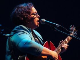 woman playing a guitar and singing