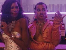 Two glamorously dressed people of colour - one pulling a shocked face, the other looking smug.