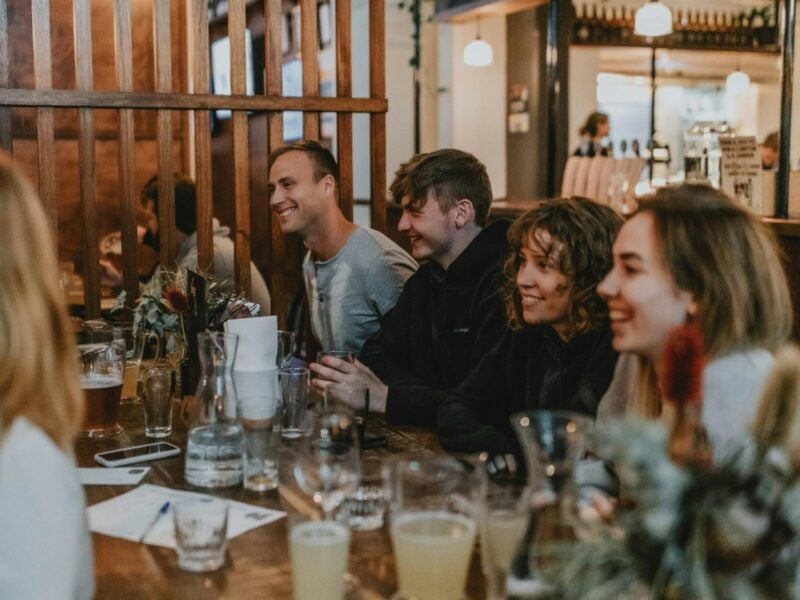 friends sitting around a table listening to the quiz questions