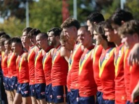 SANFL players standing arm in arm