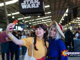 Two girls in colorful cosplay outfits smiling and taking a selfie at Supanova Comic Con and Gaming,