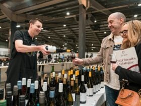 A couple enjoys a wine tasting served by a steward at Taste of the Best.