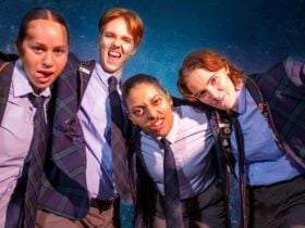 Four actors dressed as school boys in school uniforms making silly poses