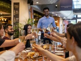 A group of people seated around a table clinking their wine glasses