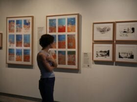 Woman stands in front of art pieces