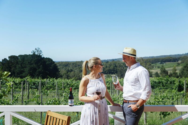 A couple enjoy a glass of wine on the Ashton Hills deck, overlooking the vineyards