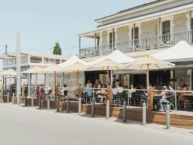 A picture of the deck at The Birkenhead Tavern, featuring outdoor umbrellas and customers dining.