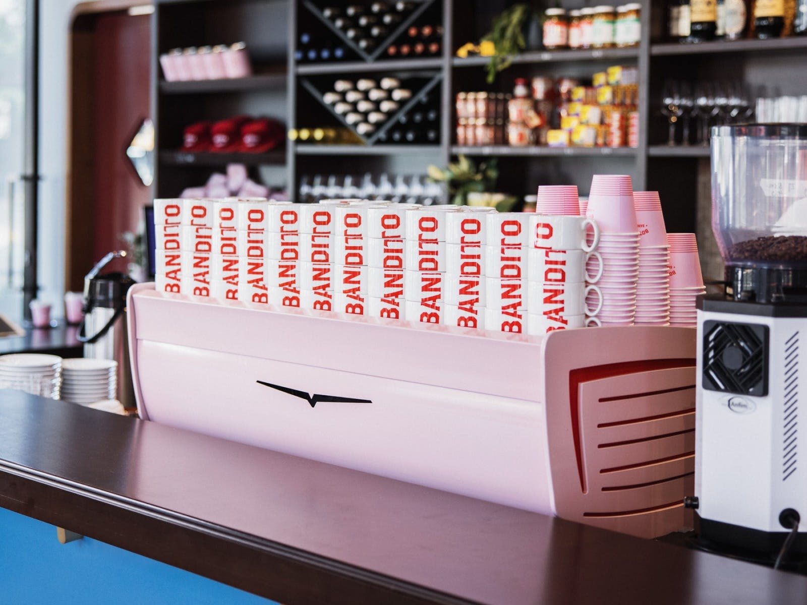 pink white eagle coffee machine with cups stacked together that say 
