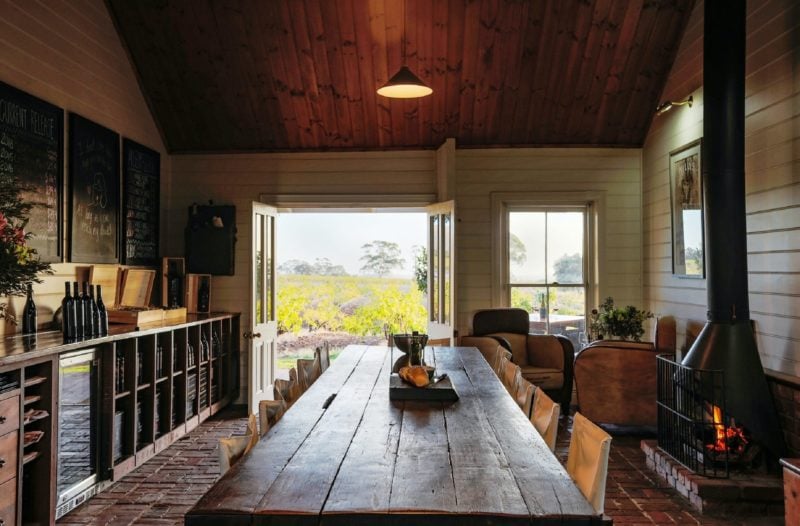 Image of tasting room showing tasting table and view of the vineyard though the french doors.