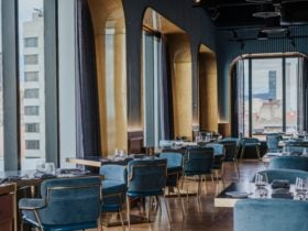 View of restaurant tables and floor to ceiling windows indicating city views