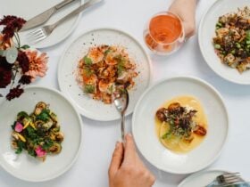 Colourful plates of food, from the Golding Wines Seasonal Plates menu, fill a white clothed table.