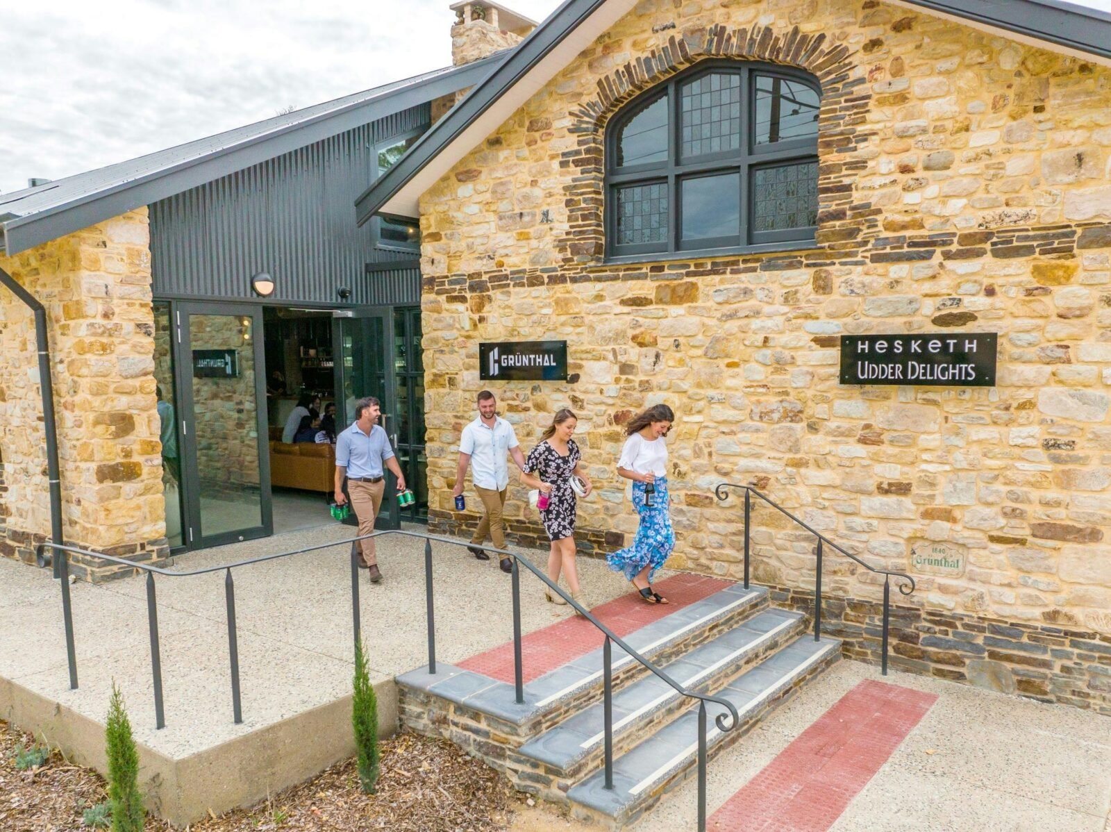 4 people walking out of building