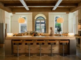 Wide shot of the travertine bar and stools at OMADA Bar & Grill facing out onto Currie Street