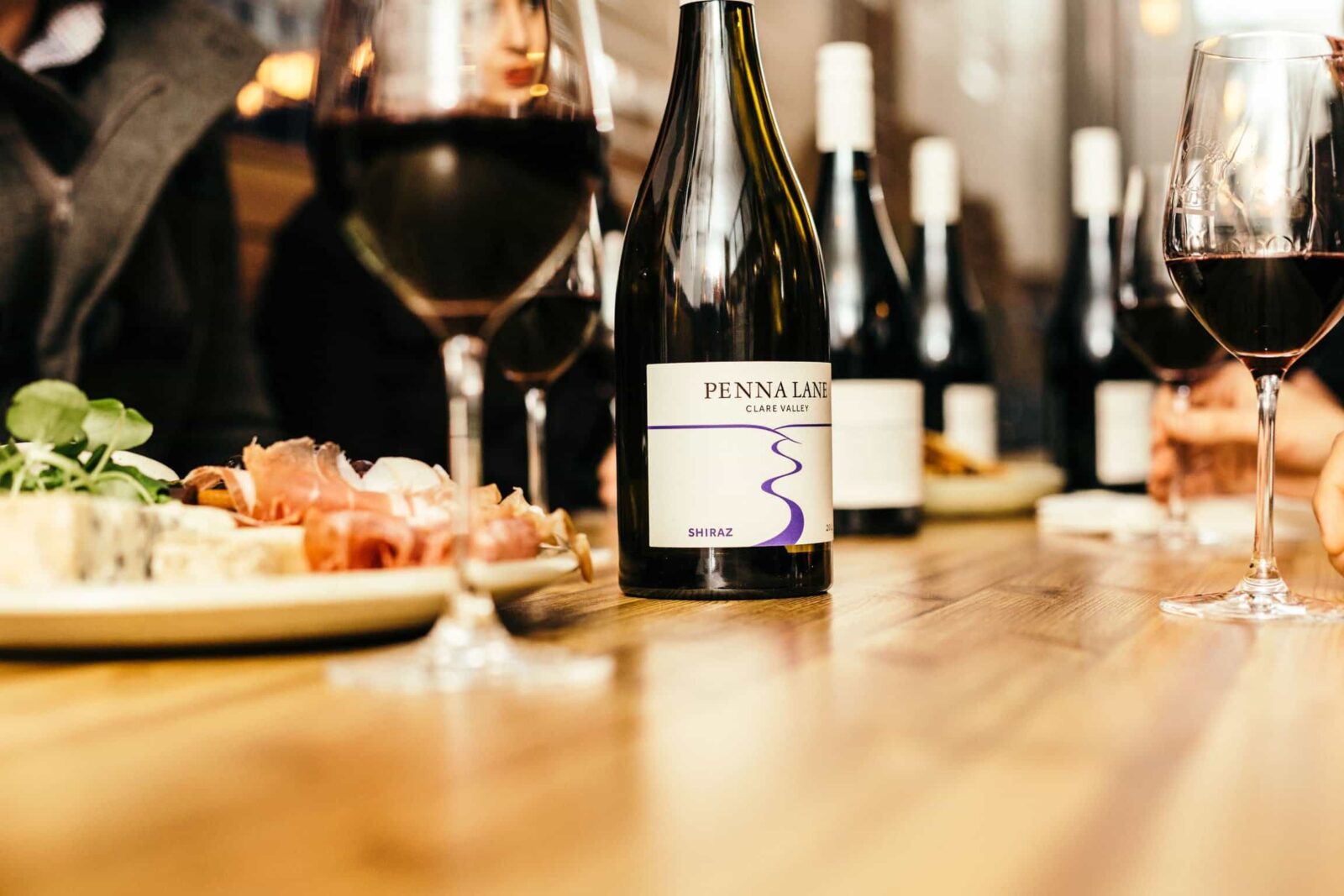 Photo of bottle of shiraz, glasses and food platter