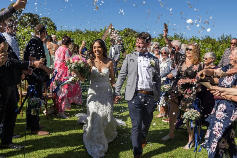 Bride & Groom walking down the aisle, with confetti falling all around them.