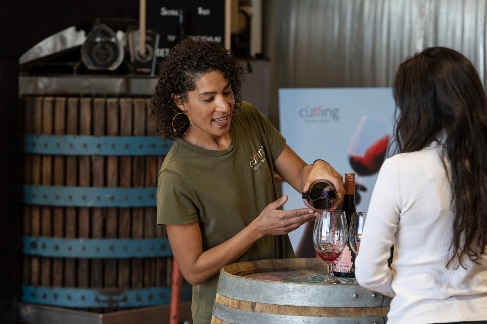 Belinda pouring The Outlier Grenache during a tasting with a young lady