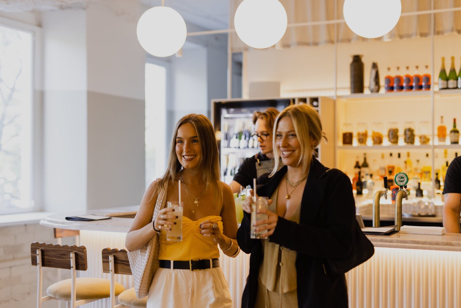2 ladies with cocktails at the bar