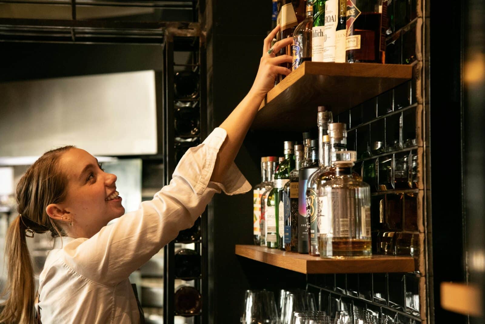 Lion Hotel staff restocking spirits behind a modern bar setup.