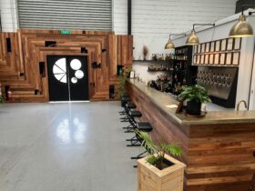 welcoming entrance to bar featuring friendly plants and rustic modern wood and concrete decor