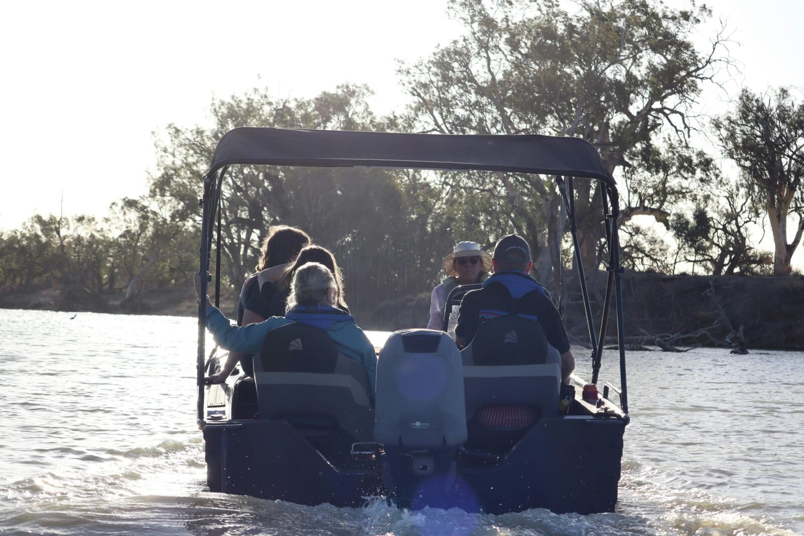 a small boat on a creek with four passengers in the Riverland of South Australia