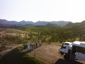 Group at a mountain lookout with the vehicle behind them
