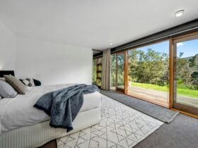 Master bedroom has an adjoining deck overlooking the river.