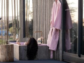 A woman soaking in a pink outdoor cast-iron bath on the deck of Tiers Rest.
