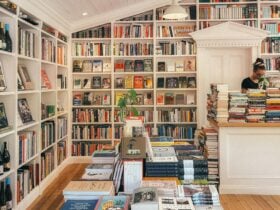 Interior of a bookshop with shelves of books and a central table stacked with titles.