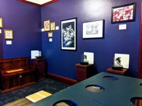 Art gallery with an array of pictures on a purple wall