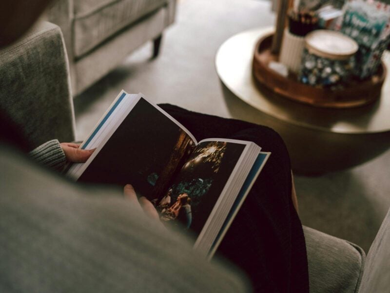 A close up of a person sitting and looking at a book.