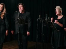 Australian Vocal Ensembe: 4 vocalists wearing black stand in-front of microphones and music stands.