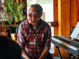 A man laughing sits at a keyboard