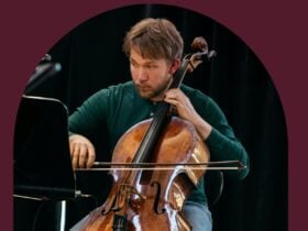 A musician playing the cello with a maroon background