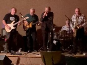 5 men on stage playing and singing