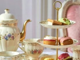 pretty high teas setting with cakes, biscuits and pastries with elegant china wear and teapot